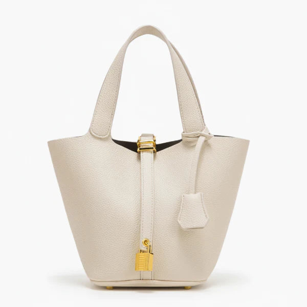Lunelia Vegan Leather Bucket Bag in white, front studio view showcasing tapered bucket silhouette, twin handles, and gold padlock charm with base feet