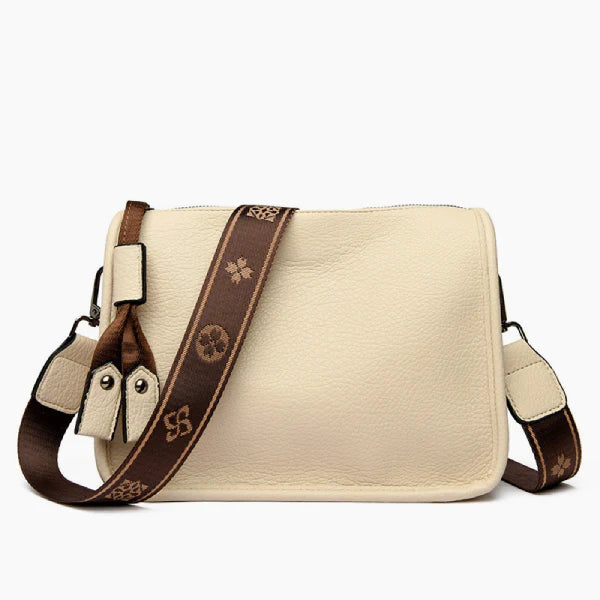 Auralis Genuine Cowhide Crossbody Bag in off-white, front studio view showcasing rectangular silhouette, zip-top closure, and adjustable patterned strap