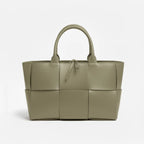 Front view of Aurelia green genuine leather tote bag with woven texture, leather handles, and tie closure