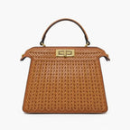 Front view of brown woven vegan leather satchel bag with gold clasp, handle, and structured design