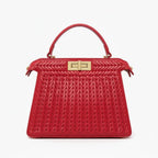 Front view of red woven vegan leather satchel bag with gold clasp, handle, and structured design
