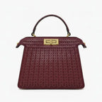 Front view of Aurora vegan leather satchel bag in wine red with woven texture and gold clasp