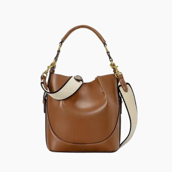 Calypso Vegan Leather Crossbody Bag in brown, front studio view showcasing structured bucket silhouette, top handle, and adjustable shoulder strap