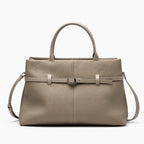 Front view of a khaki genuine leather tote bag featuring a simple yet sophisticated design with a central buckle accent