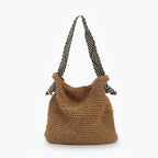 Front view of brown woven tote bag with striped black and white handles, designed for casual and beach outings