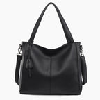 Front view of a black vegan leather tote bag with minimalist design, complemented by sturdy straps and a tassel detail