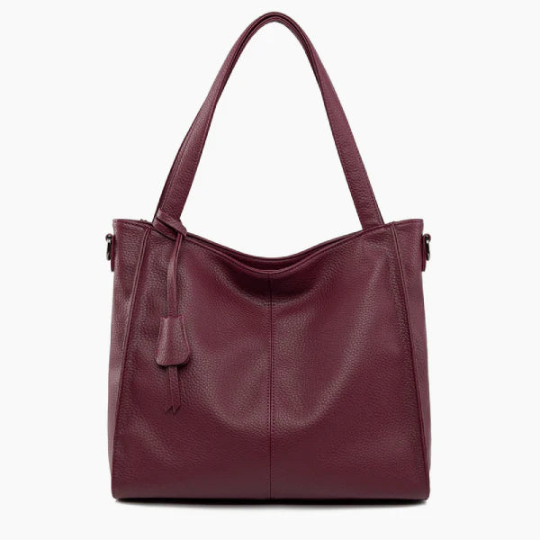 Front view of the wine red vegan leather tote bag featuring a minimalist design with a central tassel detail and elegant handles