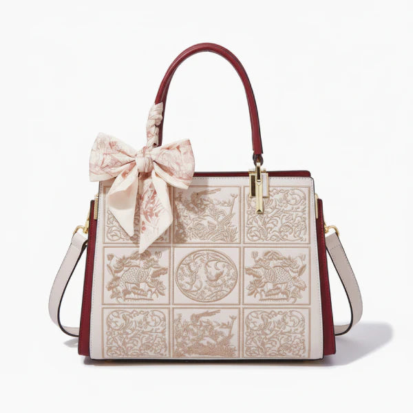 Front view of the off-white Elisandra embroidered tote bag, featuring detailed floral patterns and a stylish bow accent for a chic look