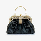 Front view of a black vegan leather evening bag with a rhinestone-studded gold frame and pleated design