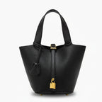 Lunelia Vegan Leather Bucket Bag in black, front studio view showcasing tapered bucket silhouette with padlock charm and base feet
