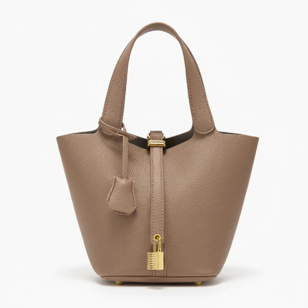 Lunelia Vegan Leather Bucket Bag in brown, front studio view showcasing tapered bucket silhouette, gold padlock charm, and base feet