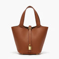 Lunelia Vegan Leather Bucket Bag in caramel, front studio view showcasing tapered bucket silhouette with twin handles and padlock charm
