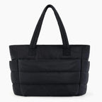 Front view of black puffer-style tote bag featuring quilted texture and strong, comfortable handles