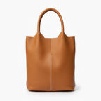 Front view of caramel cowhide leather tote bag with smooth leather finish and central seam, offering a sophisticated and minimalist design