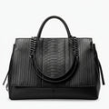 Front view of black genuine leather tote bag with textured and smooth leather panels, featuring stylish chain handles