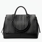 Front view of black genuine leather tote bag with textured and smooth leather panels, featuring stylish chain handles
