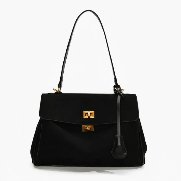 Front view of black velvet satchel bag featuring two gold clasps and a structured design