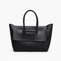 Front view of black vegan leather tote bag with structured design and elegant flap closure for a sophisticated look