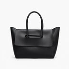 Front view of black vegan leather tote bag with structured design and elegant flap closure for a sophisticated look