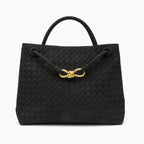 Front view of the Veyra vegan leather tote bag in black, featuring a woven texture and gold-tone knot closure for a sophisticated touch