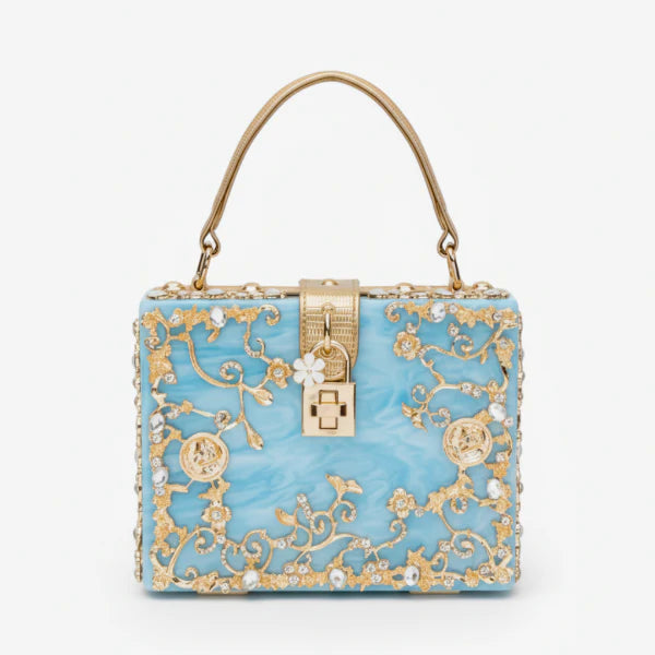 Front view of Zephyra acrylic evening bag in blue with intricate gold floral design and lock clasp