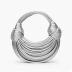 Zyra Vegan Leather Evening Bag in silver, front studio view showcasing crescent silhouette with layered cord texture and knotted handles